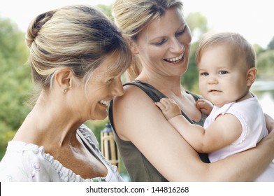 Grandmother with mother and daughter against the lake