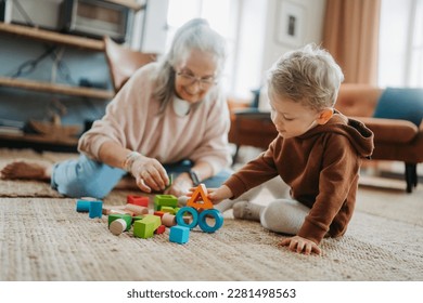 Grandmother playing with her little grandson,building a block set. - Powered by Shutterstock