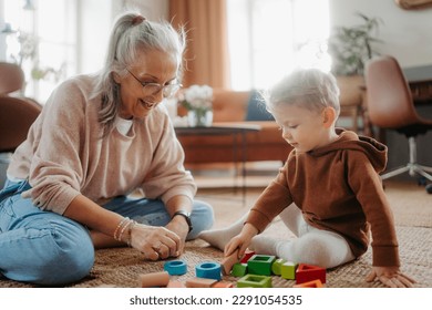 Grandmother playing with her little grandson,building a block set. - Powered by Shutterstock