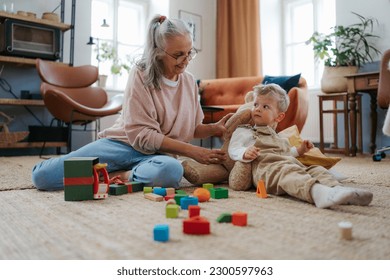 Grandmother playing with her little grandson,building a block set. - Powered by Shutterstock