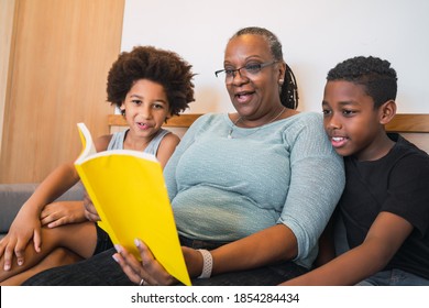 Grandmother Reading A Book To Grandchildren.