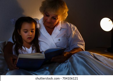 Grandmother Is Reading Fairy Tale To Her Little Granddaughter