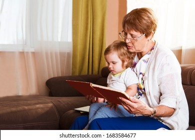 Grandmother reading a tale to her baby granddaughter. Family Reading Leisure. Quality Time. Happy Family having fun playing at home.    - Powered by Shutterstock