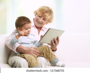 Grandmother reading a tale to her grandson from a digital tablet - Powered by Shutterstock