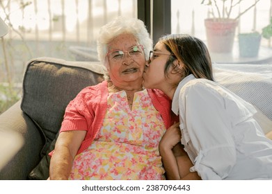 Grandmother receives a kiss from her loving granddaughter. - Powered by Shutterstock