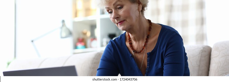 Grandmother Sits Sofa In Laptop With Credit Card. Registration And Use Internet Banking During Quarantine. Find Out Amount Required Payment On Loan Or Card With Limit. Activate Card Or Change PIN