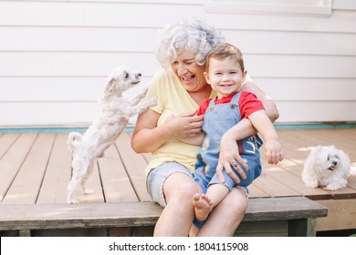 Grandmother sitting with grandson boy on porch at home backyard. Bonding of relatives and generation communication. Old woman with baby having fun spending time together outdoor.  - Powered by Shutterstock