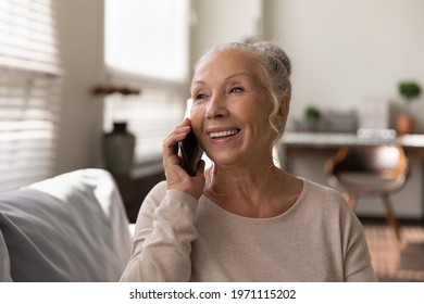 Grandmother Talking On Phone. Positive Happy Older Female Pensioner Speak Chat On Telephone Holding Modern Gadget To Ear. Excited Mature Woman Making Answering Call Using Cell Enjoy Good Conversation