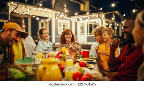 Grandmother Telling Funny Childhood Stories to Her Diverse Family and Multicultural Friends During a Festive Outdoors Dinner Table with Grilled Barbecue Meat and Lots of Fresh Vegetables. - Powered by Shutterstock