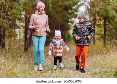 Grandmother And Two Grandchildren Running Through The Woods