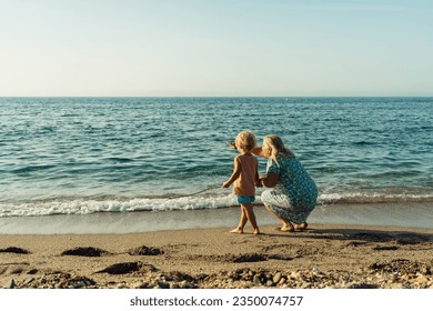 grandmother walks with her grandson on the beach on the sand by  - Powered by Shutterstock