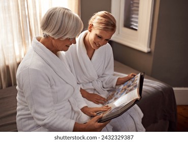 Grandmother, woman and hospitality at home, hotel and happy for bonding and looking at photo album memories. Senior lady, daughter and moment for self care, robe and bedroom for comfort and spa day - Powered by Shutterstock