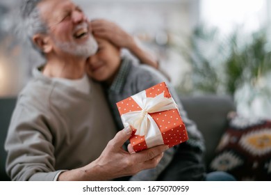 Grandpa Giving His Grandson Birthday Gift. Grandfather Becomes Present From Grandchild