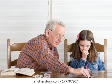 Grandpa And Granddaughter Playing Memory Game With Cards