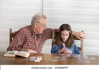 Grandpa And Granddaughter Playing Memory Game With Cards