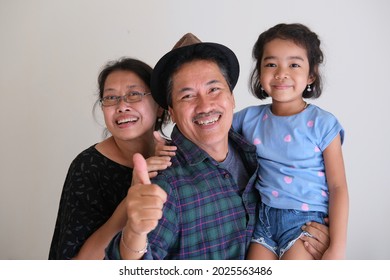 grandpa and grandma posing with their cute granddaughter wearing casual clothing. Kakek nenek dan cucu perempuan