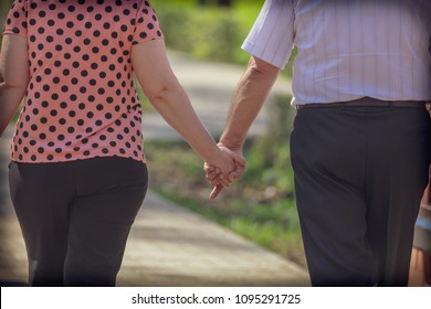 Grandpa And Grandmother Are Walking In The Park