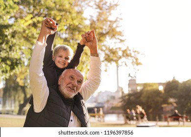Grandpa and grandson enjoying each other's company in a park in autumn. - Shutterstock ID 1196397856