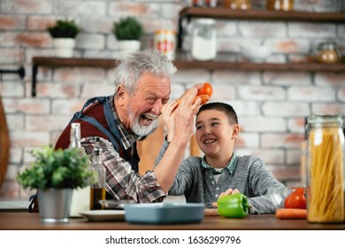 Grandpa And Grandson Playing. Old Man Cooking In Kitchen With Grandson. 