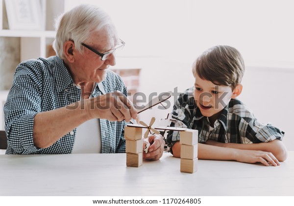 Grandpa\
and Grandson Playing with Toys at Home. Family Relationship Between\
Grandfather and Grandson. Grandpa Teaching, Male Grandchild,\
Learning Concept. Relations and People\
Concept.