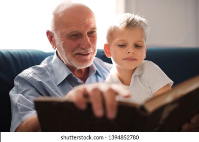 Grandpa and grandson reading a book together - Shutterstock ID 1394852780