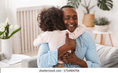 Grandparent Grandchild Relationship Concept. Senior African American Man Hugging His Granddaughter At Home