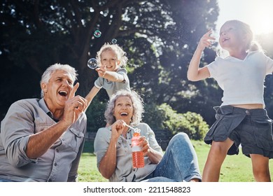 Grandparents, bubbles and children play in park happy together for fun, joy and outdoor happiness. Retired, smile and excited elderly senior couple, girl grandkids and love playing outside in nature