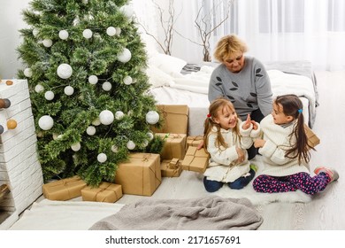 Grandparents And Children Having Fun During Christmas Day Celebration At Home With Family