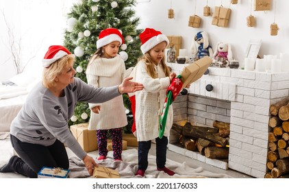 Grandparents And Children Having Fun During Christmas Day Celebration At Home With Family