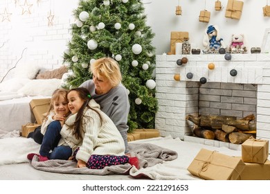 Grandparents And Children Having Fun During Christmas Day Celebration At Home With Family