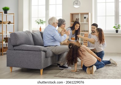 Grandparents Come To Visit. Happy Multi Generational Family Playing Board Game At Home. Mom, Dad, Granny, Granddad, Children Gather In Modern Living Room, Build Tumble Tower, Enjoy Good Time Together