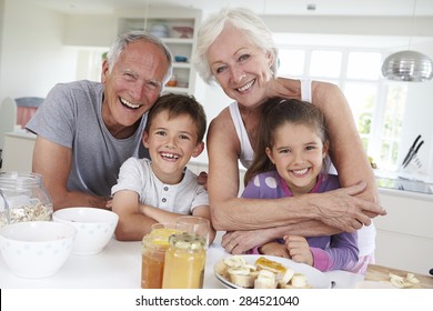 Grandparents With Grandchildren Eating Breakfast In Kitchen