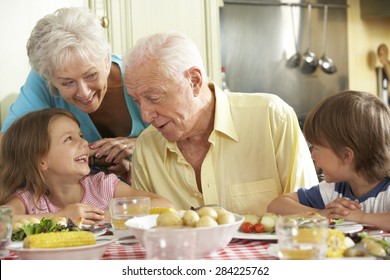 Grandparents And Grandchildren Eating Meal Together In Kitchen - Powered by Shutterstock