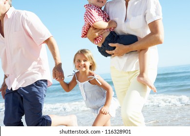 Grandparents And Grandchildren Enjoying Beach Holiday