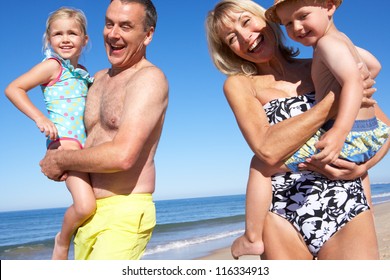 Grandparents And Grandchildren Enjoying Beach Holiday