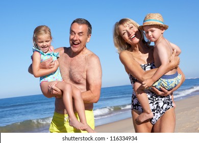 Grandparents And Grandchildren Enjoying Beach Holiday