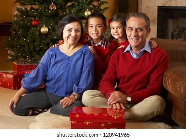 Grandparents With Grandchildren In Front Of Christmas Tree