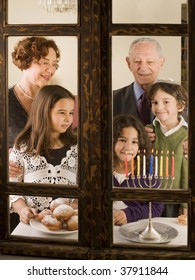 grandparents and grandchildren with Hanukkia, at the window