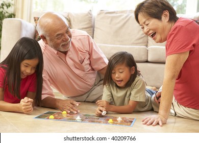 Grandparents And Grandchildren Playing Board Game At Home