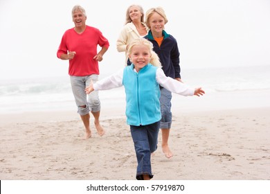 Grandparents And Grandchildren Running On Winter Beach Together