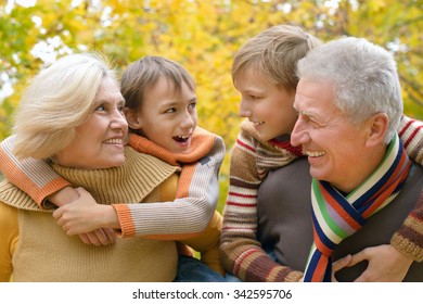 Grandparents And Grandchildren Together In Autumn Park