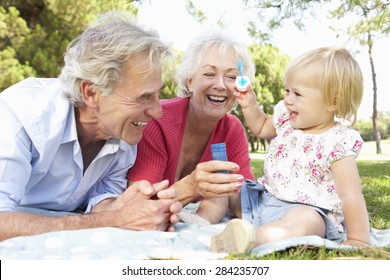 Grandparents And Granddaughter Playing In Park Together - Powered by Shutterstock