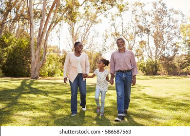 Grandparents And Granddaughter Walking In Park Together - Powered by Shutterstock