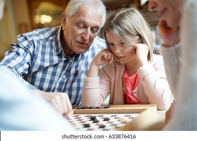 Grand-parents With Grandkids Playing Checkers