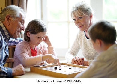 Grand-parents With Grandkids Playing Checkers