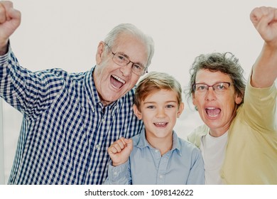 Grandparents and Grandson Showing Winning Gesture