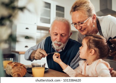 Grandparents having breakfast with their granddaughter
