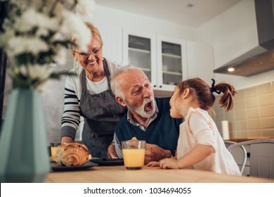 Grandparents having breakfast with their granddaughter