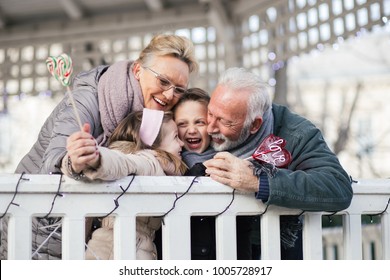 Grandparents having fun with their grandchildren in city park.