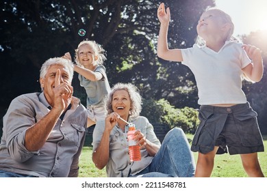 Grandparents, Kids And Play With Bubbles In The Park, Nature Or Outdoors. Love, Smile And Happy Girls Having Fun, Bonding And Spending Quality Time With Grandma And Grandpa On Grass With Soap Toy.